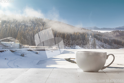 Image of Single tea or coffee cup and landscape of mountains on background