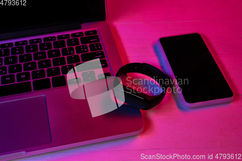 Image of Top view of set of gadgets in purple neon light