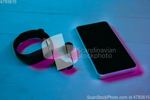 Image of Top view of set of gadgets in purple neon light