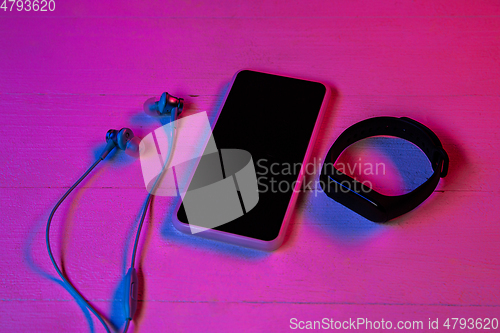 Image of Top view of set of gadgets in purple neon light