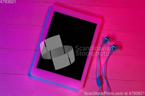 Image of Top view of set of gadgets in purple neon light