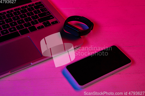 Image of Top view of set of gadgets in purple neon light