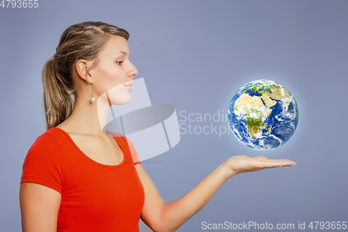 Image of woman watching planet earth above her hand