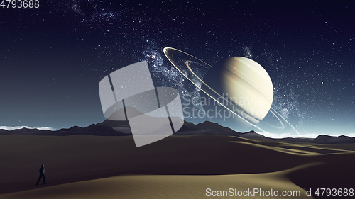 Image of desert planet with explorer and saturn at the horizon