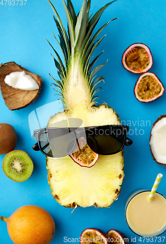 Image of pineapple in sunglasses with other exotic fruits