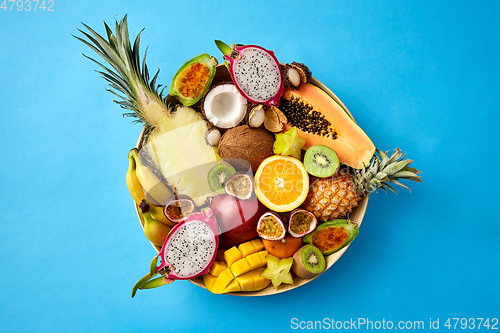 Image of plate of exotic fruits on blue background