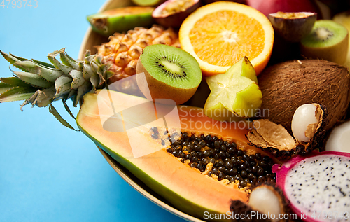 Image of plate of exotic fruits on blue background