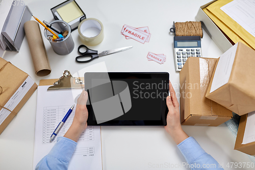 Image of hands with tablet pc and clipboard at post office