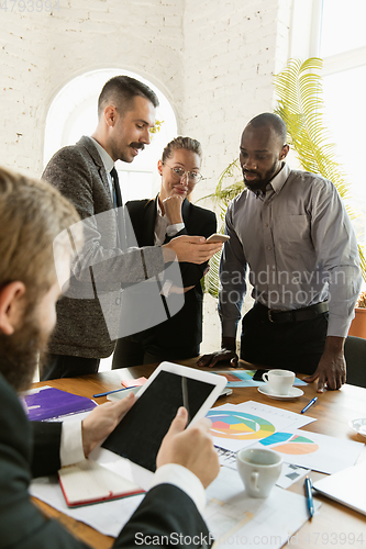 Image of Group of young business professionals having a meeting, creative office