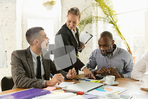 Image of Group of young business professionals having a meeting, creative office
