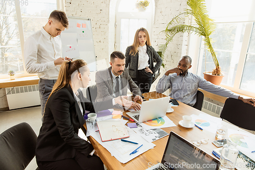Image of Group of young business professionals having a meeting, creative office