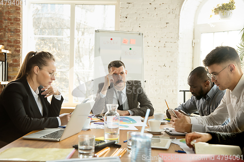 Image of Group of young business professionals having a meeting, creative office