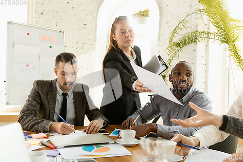 Image of Group of young business professionals having a meeting, creative office