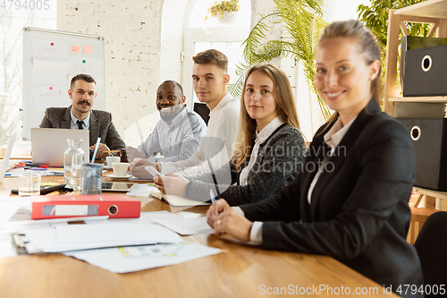Image of Group of young business professionals having a meeting, creative office