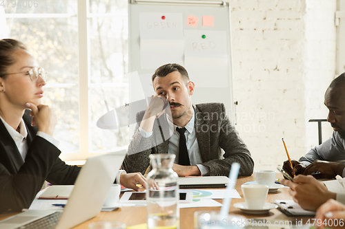 Image of Group of young business professionals having a meeting, creative office
