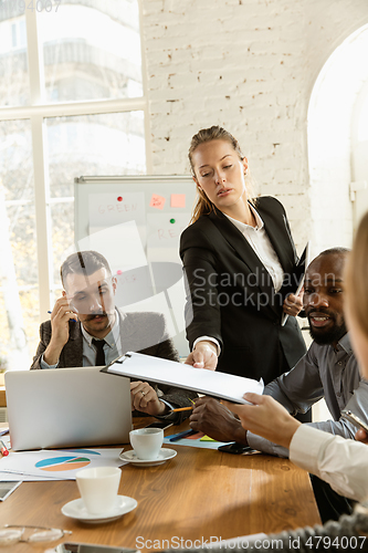 Image of Group of young business professionals having a meeting, creative office