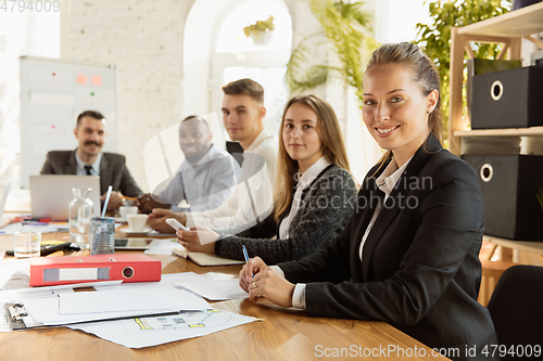 Image of Group of young business professionals having a meeting, creative office