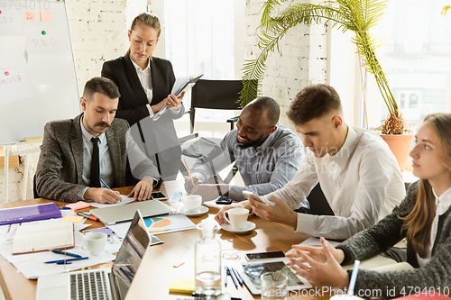 Image of Group of young business professionals having a meeting, creative office