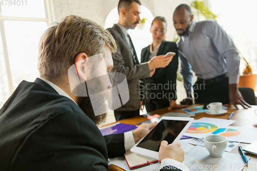 Image of Group of young business professionals having a meeting, creative office