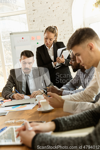 Image of Group of young business professionals having a meeting, creative office