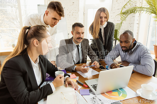 Image of Group of young business professionals having a meeting, creative office