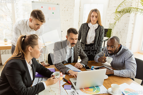 Image of Group of young business professionals having a meeting, creative office