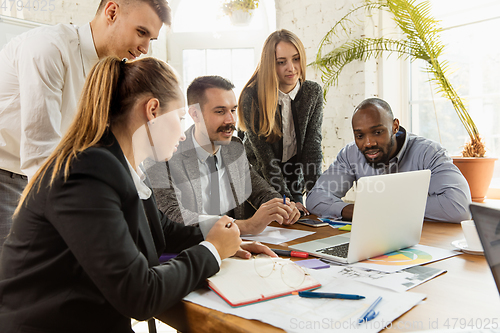 Image of Group of young business professionals having a meeting, creative office
