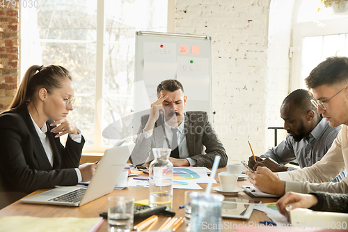 Image of Group of young business professionals having a meeting, creative office