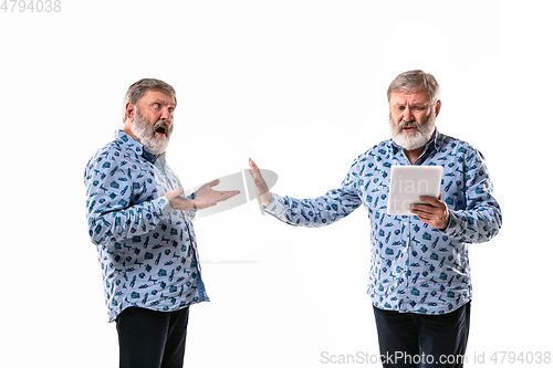 Image of Senior man arguing with himself on white studio background.