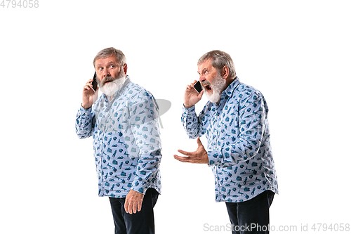 Image of Senior man arguing with himself on white studio background.