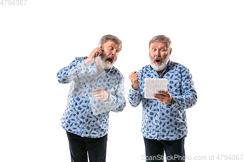 Image of Senior man arguing with himself on white studio background.