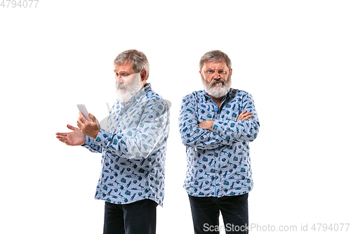 Image of Senior man arguing with himself on white studio background.