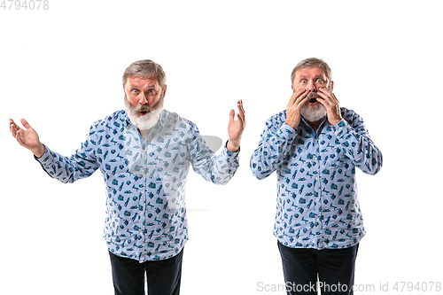 Image of Senior man arguing with himself on white studio background.