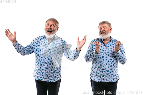 Image of Senior man arguing with himself on white studio background.