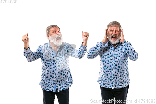 Image of Senior man arguing with himself on white studio background.