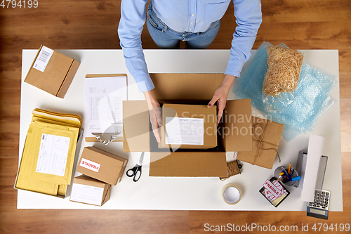 Image of woman packing parcel boxes at post office