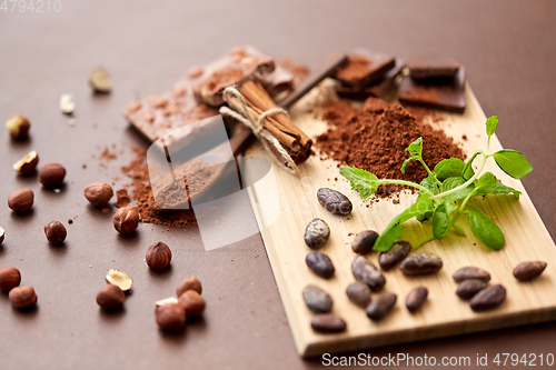 Image of chocolate with nuts, cocoa beans and cinnamon