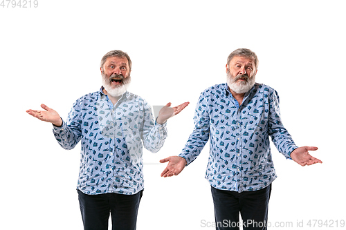 Image of Senior man arguing with himself on white studio background.