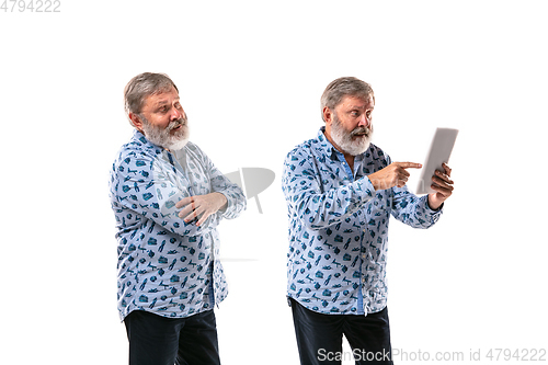 Image of Senior man arguing with himself on white studio background.