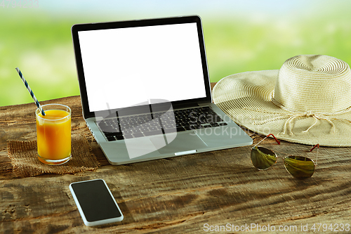 Image of Blank laptop on a wooden table outdoors, mock up