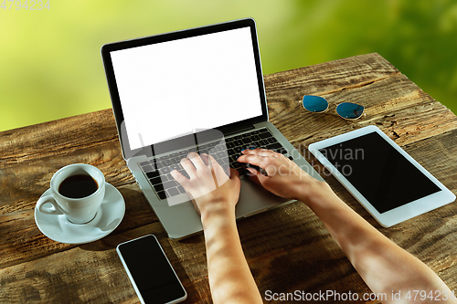 Image of Blank laptop on a wooden table outdoors, mock up
