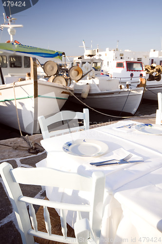 Image of taverna setting in harbor with fishing boats