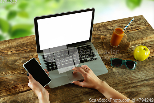 Image of Blank laptop on a wooden table outdoors, mock up