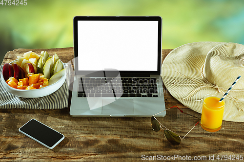 Image of Blank laptop on a wooden table outdoors, mock up