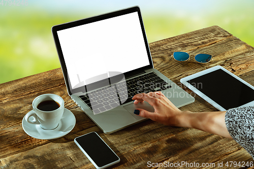 Image of Blank laptop on a wooden table outdoors, mock up
