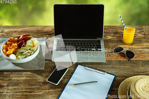 Image of Blank laptop on a wooden table outdoors, mock up