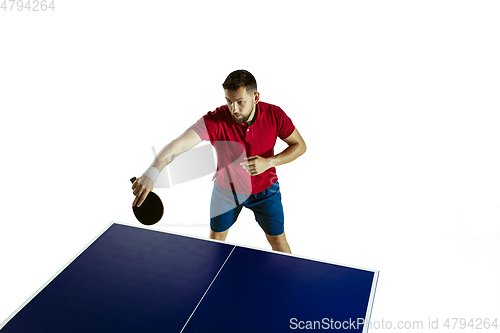 Image of Young man playing table tennis on white studio background