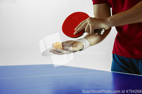 Image of Young man playing table tennis on white studio background