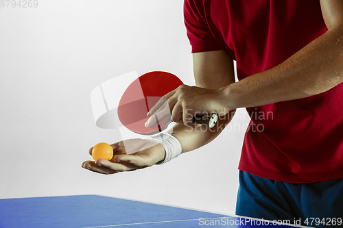 Image of Young man playing table tennis on white studio background