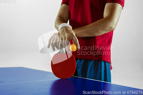 Image of Young man playing table tennis on white studio background